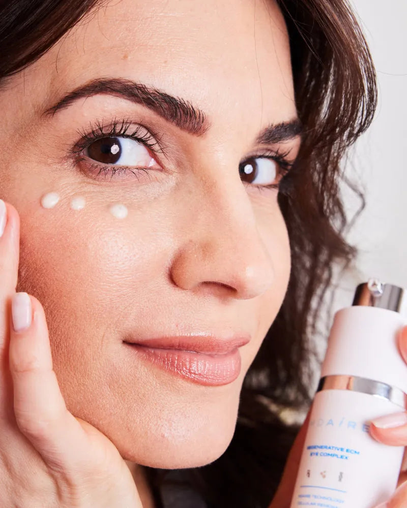 Woman applying eye cream from Brightening Trio to under eye area with 