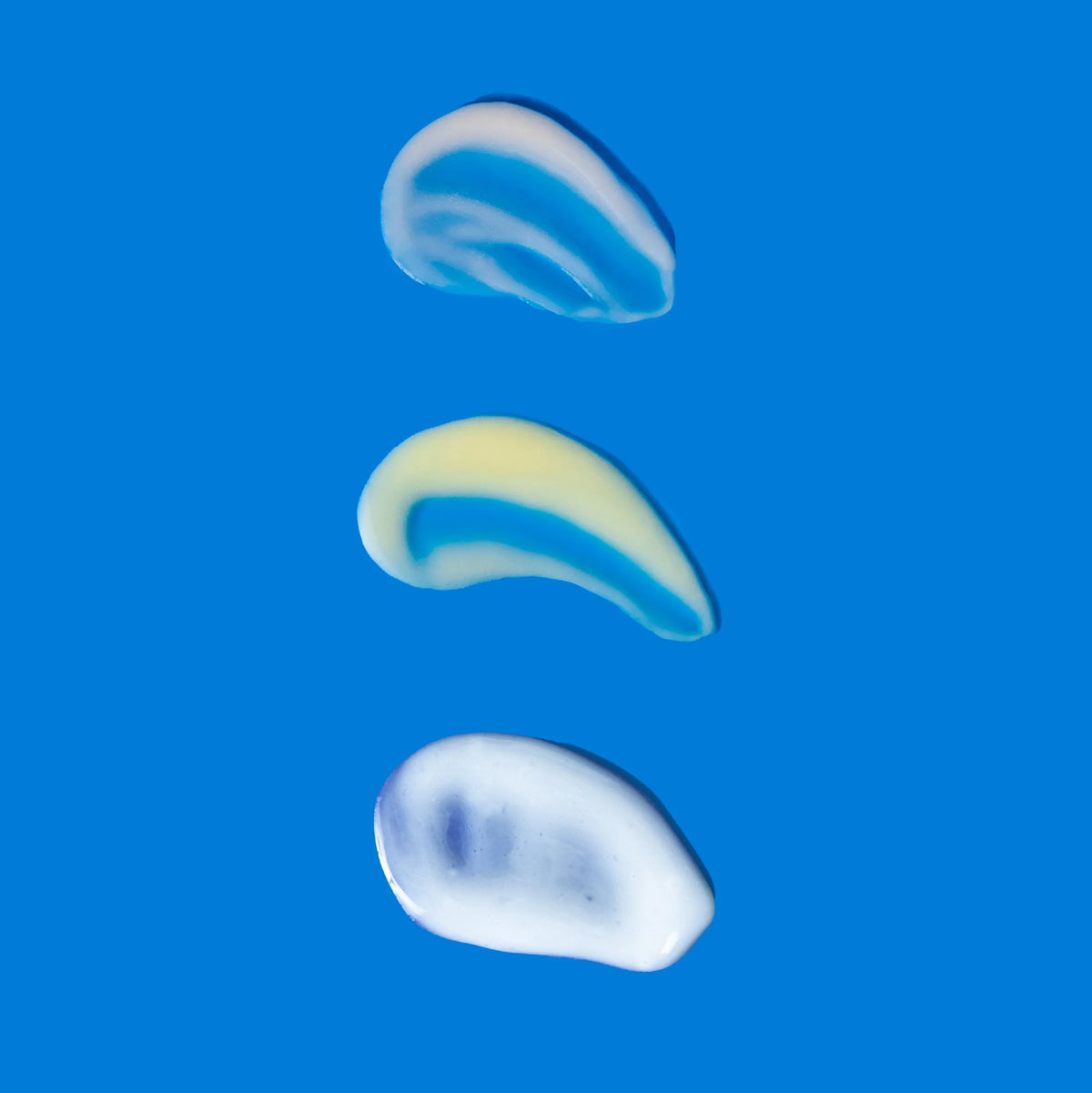 Three distinct cream textures from Triple Threat Trio displayed on blu