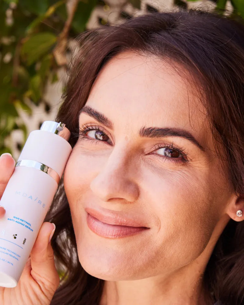 Woman holding RXR Retinol Anti-Aging Serum by Dr. Stefani Kappel, prom
