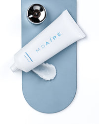 Cloud Polish exfoliant tube with opened cap and swatch on blue surface shown in gallery position 1