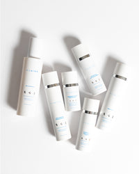 Complete System Bundle with six sleek white MDAiRE skincare bottles arranged on a bright white surface gallery position 1